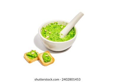 Ramson pesto with olive oil, parmesan, and pine nuts isolated on white background. Bowl of fragrant spread, spicy appetizer, or ingredient for cooking food. A hard light, dark shadow