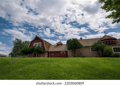 Ranch Home On Grassy Hill With Weathervane And Cloudy Blue Sky