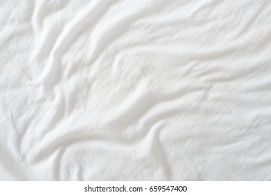 Random Abstract Pattern Of A White Crumpled Bed Sheet In A Hotel Room. The Manufacturing Of Bedsheet Uses Cotton, Cotton Blends, Polyester And Others Fibers Such As Linen, Silk Modal And Bamboo Rayon.