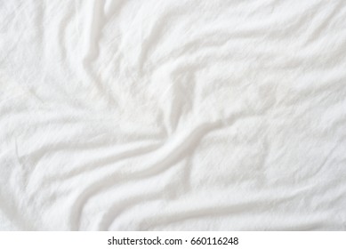 Random Abstract Pattern Of A White Crumpled Bed Sheet In A Hotel Room. The Manufacturing Of Bedsheet Uses Cotton, Cotton Blends, Polyester And Others Fibers Such As Linen, Silk Modal And Bamboo Rayon.