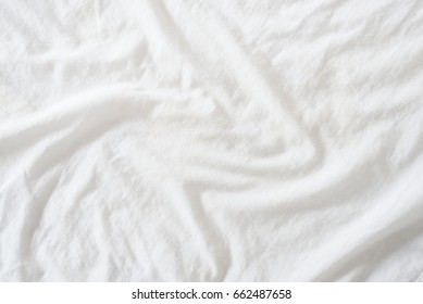 Random Abstract Pattern Of A White Crumpled Bed Sheet In A Hotel Room. The Manufacturing Of Bedsheet Uses Cotton, Cotton Blends, Polyester And Others Fibers Such As Linen, Silk Modal And Bamboo Rayon.