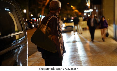 Random Person With A Shoulder Bag Looking Forward Trough The Street At Evening Time