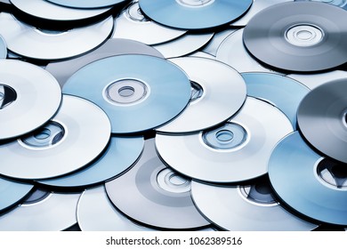 Random silver and grey DVD and CD disks create data concept background