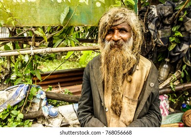 RANGAMATI, BANGLADESH - NOVEMBER 12, 2017: Homeless man with long uncut hair and a very long brown beard that was not trimmed for the last few years is posing