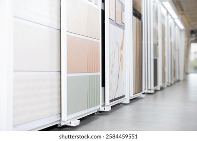 Range of natural and technical stone tile samples in different colors and textures displayed on sliding panels in showroom, showcasing design options for interiors