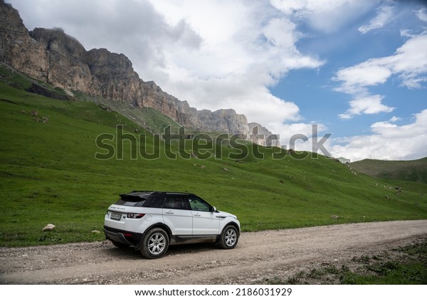 Range\
Rover Evoque car on the background of the mountains of the North\
Caucasus in Russia. Cloudy day on June 10,\
2022
