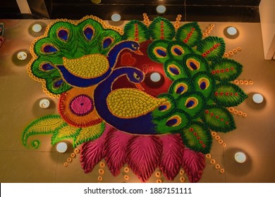 Rangoli Design Of Colorful Peacock At Entrance Of The Door With Small Wax Tealights Diya Around It