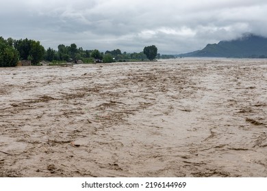 A rapid stream of muddy rain water entering in the river - Shutterstock ID 2196144969