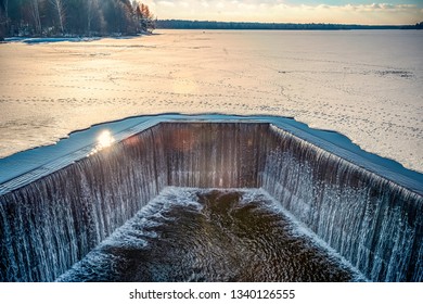 rapid stream of water falling down from a concrete dam