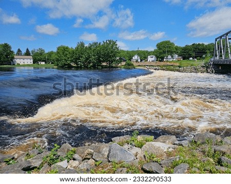 Rapid water going down a river from a small waterfall.
