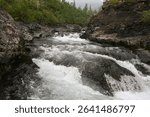 Rapids on a mountain stream. Cloudy landscape, Grayling creek on the Putorana plateau.