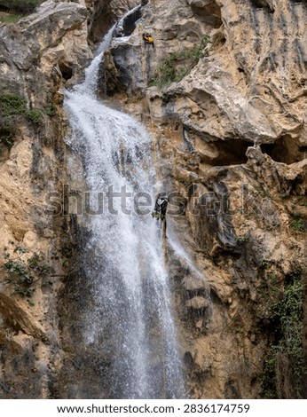 rappelling down a large waterfall