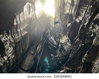 Rappelling down a vertical cave