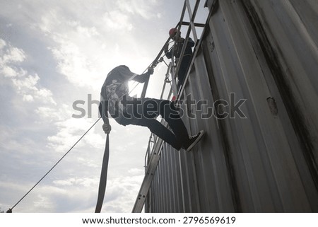  Rappelling training exercise involving several individuals on a large, corrugated metal structure container.