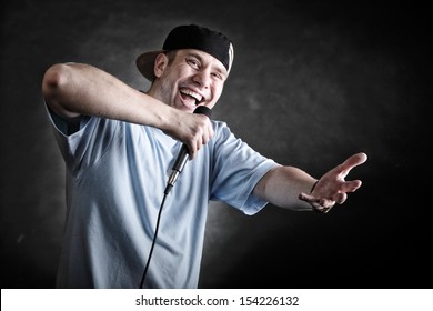 Rapper Attitude Rap Singer Hip Hop Dancer Performing. Young Man With Microphone Singing Hand Cool Gesture Black Grunge Background