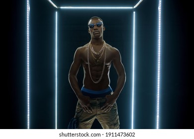 Rapper In Gold Chains Dancing In Illuminated Cube