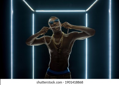 Rapper In Gold Chains Poses In Illuminated Cube