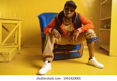 Rapper posiert im Stuhl mit gelben Tönen