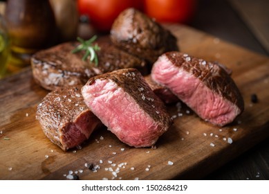 rare grilled tenderloin beef steak on cutting board with vegetables - Shutterstock ID 1502684219
