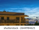 Rare Noctilucent Clouds Glowing Over the City at Night.