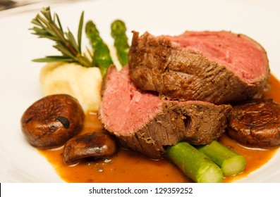 Rare Prime Rib Beef On A Plate With Mushrooms, Gravy, Asparagus, Potatoes And Rosemary