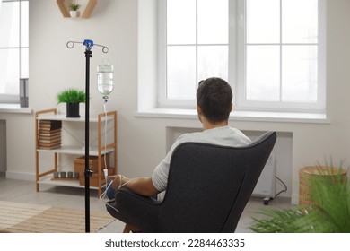 Rare view of man sitting in armchair during intravenous therapy. Male patient getting treatment in medical clinic or wellness center. Medical treatment, healthcare concept - Powered by Shutterstock