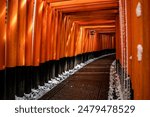 A Rare Winter snow at Torii Gate Tunnel at Fushimi Inari Shrine in Kyoto Japan. Orange and black beams with traditional Japanese Lanterns