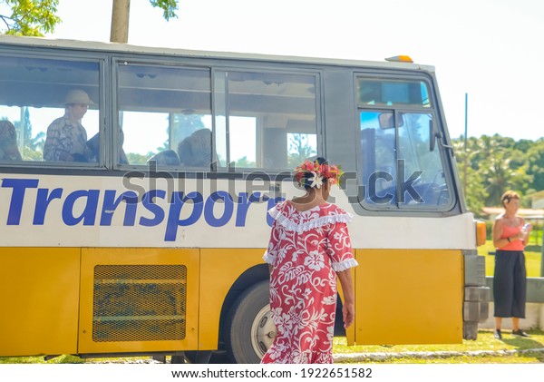 Rarotonga, Cook Island: 09\
May 2019: view of People workers in traditional and typical costume\
on Rarotonga, beautiful beach place in Cook Island with blue sea\
and white sand.