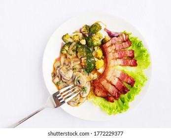 Rasher of bacon with creamy mushroom stew and broccoli on white plate. Low-carb ketogenic food top view, flat lay