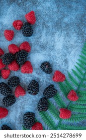 Raspberries and blackberries. Good for diet. Top view. Close-up on blue stone background