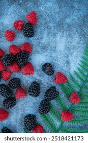 Raspberries and blackberries. Good for diet. Top view. Close-up on blue stone background