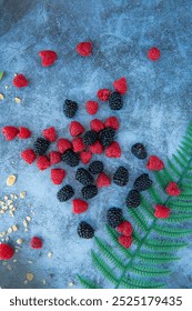 Raspberries and blackberries. Good for diet. Top view. Close-up on blue stone background