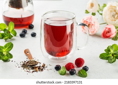 Raspberries and blueberries tea with fresh berries on white background
