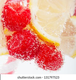 Raspberries And Lemon Slices In Sparkling Water.  Macro.  Focus On Bubbles.