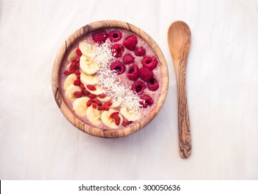 Raspberry Banana Smoothie Bowl Topped With Raspberries, Banana, Coconut And Goji Berries 