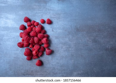 raspberry berries on gray background, free space for text