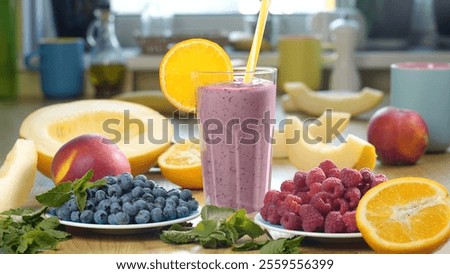 Raspberry Blueberry Melon Smoothie into a glass on the background of fresh fruits and berries. The fruit cocktail is ready to eat. Healthy and vegetarian food concept