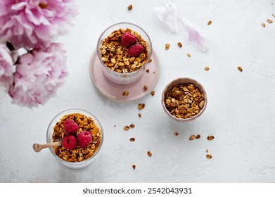 Raspberry chia seed parfait made with granola and berries in a cups with peony and petals on the background. Healthy fancy breakfast. Brunch - Powered by Shutterstock