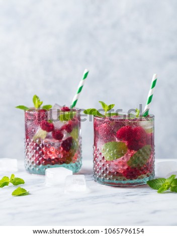 Raspberry cocktail, fizz, lemonade, ice tea with fresh mint on marble background. Copy space.