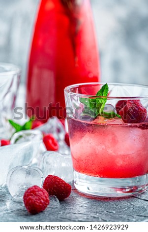 Raspberry cocktail, fizz, lemonade, ice tea with fresh mint on blue wooden background. Close up.