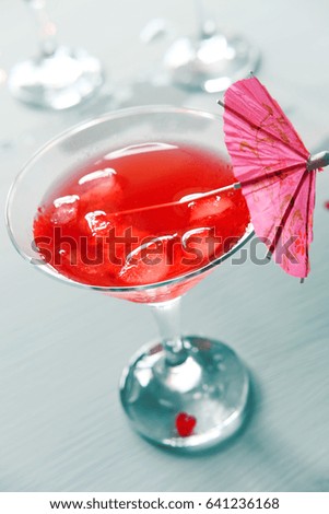 Raspberry cocktail with ice and paper umbrellas. Summer refreshing alcohol drinks for parties.