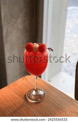 Raspberry cocktail with iced on wooden table. Spring or summer refreshing cold cocktail or mocktail.