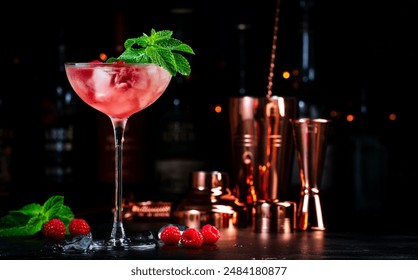 Raspberry cocktail with white rum, sugar syrup, fruit juice, lime, berry and ice in glass. Black bar counter background - Powered by Shutterstock