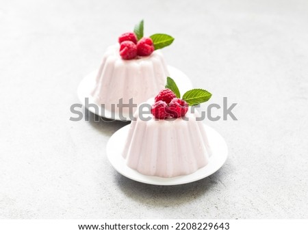 Raspberry cream pudding, jelly, Panna Cotta on a plate. Light gray background	