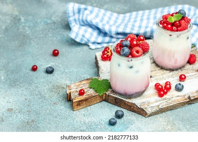 Raspberry Dessert Cheesecake, Trifle, Mouse In A Glass. Raspberry Greek Yogurt Granola Parfait On A Blue Background. Restaurant Menu, Dieting, Cookbook Recipe.