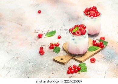 Raspberry Dessert Cheesecake, Trifle, Mouse In A Glass. Raspberry Greek Yogurt Granola Parfait On A Light Background. Restaurant Menu, Dieting, Cookbook Recipe.