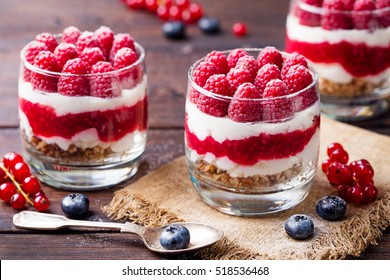 Raspberry dessert, cheesecake, trifle, mouse in a glass on a wooden background. - Shutterstock ID 518536468