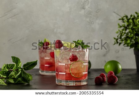 Raspberry Lime Vodka Cocktail with mint and ice. Refreshing alcoholic drink with ripe berries. copy space for recipe or text. 