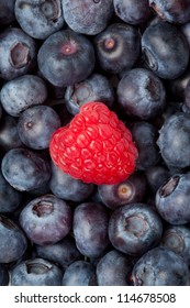 Raspberry in the middle of blueberries in a high angle view