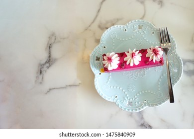 Raspberry mini cake put in a plate, placed on a white marble table background from top view.